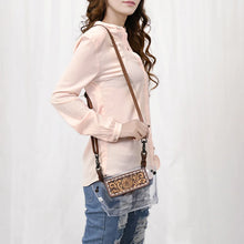 Load image into Gallery viewer, Woman wearing the Black-Eyed Susan clear crossbody purse with hand tooled sunflower flap and brown leather strap