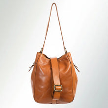 Load image into Gallery viewer, Side view of the Avalon tan leather tote hanging from its adjustable crossbody strap