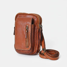 Load image into Gallery viewer, Angled view of cognac Italian leather phone crossbody with adjustable leather strap