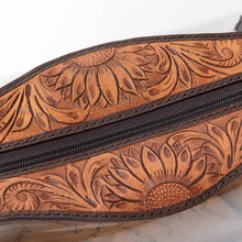 Load image into Gallery viewer, Close-up of hand tooled sunflower and scroll carving along the zipper of the Prairie Bloom toiletry bag