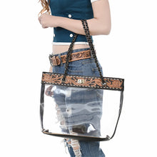 Load image into Gallery viewer, Midnight Bloom clear tote carried by its chain handles, tooled floral band at top