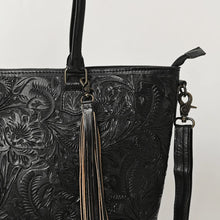 Load image into Gallery viewer, Close-up of Maple Creek black tote showing hand-tooled floral leather, fringe tassel and antique brass swivel clip