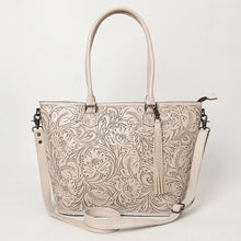 Load image into Gallery viewer, Maple Creek hand tooled leather concealed carry tote in white, front view with floral tooling, fringe tassel and shoulder strap
