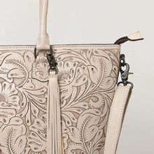 Load image into Gallery viewer, Close-up of Maple Creek white tote showing hand-tooled florals, fringe tassel and antique brass swivel clip