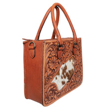 Load image into Gallery viewer, Brazos hand tooled leather tote at an angle, showing the structured shape, plain leather side gusset, antique brass D-ring for the crossbody strap, and the tooled front panel