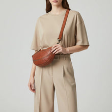 Load image into Gallery viewer, Woman wearing the Comet cognac Italian leather crescent sling bag crossbody