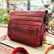 Load image into Gallery viewer, Side angle of the Washoe Lake studded leather crossbody purse with antique brass swivel snap hook on the strap