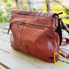 Load image into Gallery viewer, Side angle of the Venezia cognac leather crossbody purse showing back zip pocket and strap clasp