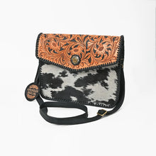 Load image into Gallery viewer, Magpie hand tooled cowhide envelope crossbody, angled view with adjustable black leather strap