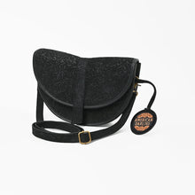 Load image into Gallery viewer, Nightshade black floral embossed suede saddle crossbody, angled view with adjustable strap