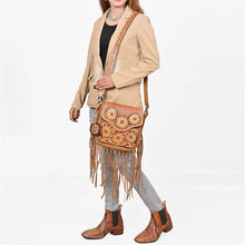 Load image into Gallery viewer, Model wearing the Solana sunflower tooled fringe crossbody with a tan blazer, gray jeans and tooled boots