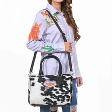 Load image into Gallery viewer, Tuff black and white hair-on cowhide speedy bag with PRCA patch and NFR charm