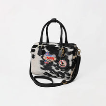 Load image into Gallery viewer, Tuff black and white hair-on cowhide speedy bag with PRCA patch and NFR charm