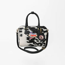 Load image into Gallery viewer, Tuff black and white hair-on cowhide speedy bag with PRCA patch and NFR charm