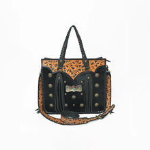 Load image into Gallery viewer, Fandango hand-tooled hair-on leather fringe tote, front view, black hair-on hide with tan floral tooled yoke, brass conchos, turquoise-tone bow concho, twin fringe tassels, and tooled strap