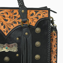 Load image into Gallery viewer, Close-up of the Fandango tote's hand-carved floral scroll yoke, antique brass conchos, turquoise-tone bow concho, leather fringe, and tooled strap