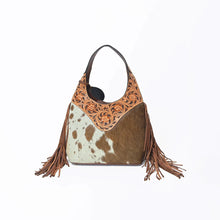 Load image into Gallery viewer, Back of the Appaloosa bag with brown-and-white cowhide and hand-tooled floral yoke