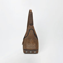 Load image into Gallery viewer, Austin western sling bag in distressed brown genuine leather, straight-on front view showing the full teardrop silhouette, vertical strap, stitched sprig motif, and studded bottom band