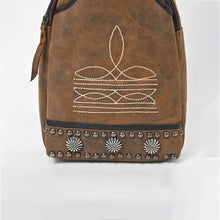Load image into Gallery viewer, Close-up of the Austin western sling bag front panel showing the cream contrast stitch sprig motif and the black-trimmed hem set with gunmetal dome studs and three starburst conchos