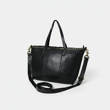 Load image into Gallery viewer, Emmylou studded Italian leather crossbody tote in black, angled view showing brass studs, shoulder handles and strap
