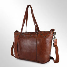 Load image into Gallery viewer, Emmylou studded Italian leather crossbody tote in cognac, angled view showing V-yoke studs, handles and strap clip

