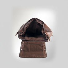 Load image into Gallery viewer, Sawyer brown leather backpack with flap open, showing the studded flap underside and lined main compartment
