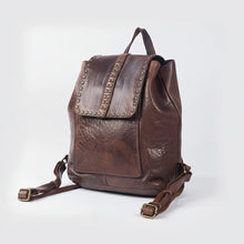 Load image into Gallery viewer, Three-quarter view of the Sawyer brown studded Italian leather backpack with top handle and brass buckles

