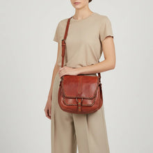 Load image into Gallery viewer, Woman wearing the cognac Walker River studded leather saddle crossbody
