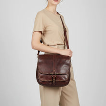 Load image into Gallery viewer, Woman wearing the dark brown Walker River studded leather saddle crossbody on the shoulder
