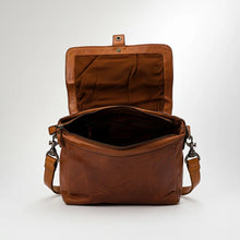 Load image into Gallery viewer, Lucca cognac leather messenger bag opened to show snap flap, fabric lining, and zip-top main compartment
