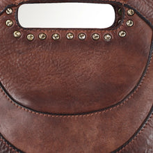 Load image into Gallery viewer, Close-up of the Selene handbag's cut-out clutch handle framed in star-stamped antique-brass-tone studs above a leather crescent panel
