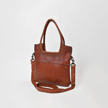 Load image into Gallery viewer, Sienna studded leather crossbody tote in cognac, angled view showing its slim profile, rolled handles and detachable strap

