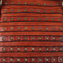 Load image into Gallery viewer, Close-up of the Rowan satchel's center panel showing layered cognac leather strips lined with star-stamped antique brass studs
