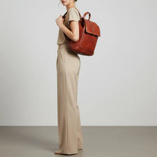 Load image into Gallery viewer, Woman wearing the Sawyer cognac studded leather backpack over one shoulder
