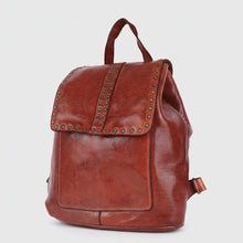 Load image into Gallery viewer, Three-quarter view of the Sawyer cognac studded Italian leather backpack with star-studded flap and top handle

