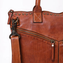 Load image into Gallery viewer, Close-up of Vivienne tote star-stamped brass studs, X-stitched handle tab, zip pocket and swivel hook
