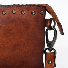 Load image into Gallery viewer, Close-up of studs and swivel clip on the Santa Rosa leather crossbody in cognac | Dodi Jo's
