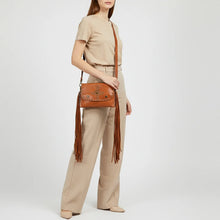 Load image into Gallery viewer, Model wearing the Estrella tan studded fringe leather crossbody over the shoulder with tailored neutral trousers
