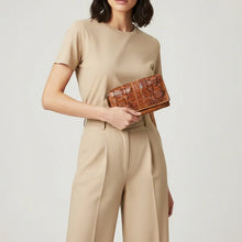 Load image into Gallery viewer, Model holding the Wren tan woven leather accordion wallet in hand, showing its size and hand-woven basketweave flap
