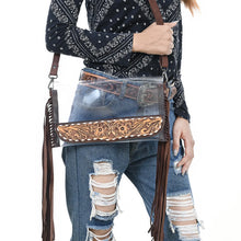 Load image into Gallery viewer, Two Step clear fringe crossbody purse worn at the hip, tooled floral panel in front
