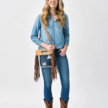 Load image into Gallery viewer, Woman in a denim shirt wearing the Cinch clear fringe crossbody purse with hand tooled top panel

