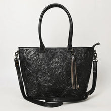 Load image into Gallery viewer, Maple Creek hand tooled leather concealed carry tote in black, front view with floral tooling, fringe tassel and shoulder strap
