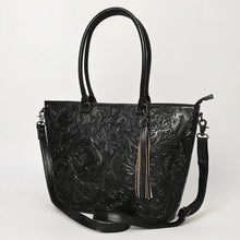 Load image into Gallery viewer, Maple Creek hand tooled leather concealed carry tote in black, angled view showing floral tooling, tassel and strap
