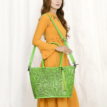 Load image into Gallery viewer, Model wearing the Maple Creek hand tooled leather concealed carry tote in green over the shoulder on its detachable strap
