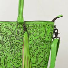 Load image into Gallery viewer, Close-up of Maple Creek green tote showing antiqued hand-tooled florals, fringe tassel and antique brass swivel clip
