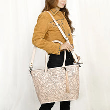 Load image into Gallery viewer, Model carrying the Maple Creek hand tooled leather concealed carry tote in white
