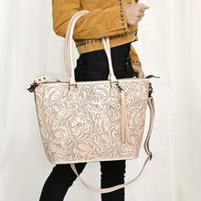Load image into Gallery viewer, Model wearing the Maple Creek hand tooled leather tote in white
