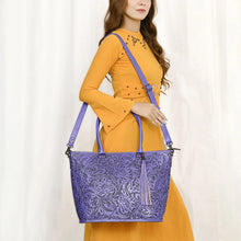 Load image into Gallery viewer, Model carrying the Maple Creek hand tooled leather concealed carry tote in purple
