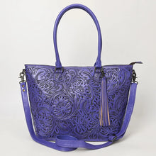 Load image into Gallery viewer, Maple Creek hand tooled leather concealed carry tote in purple, front view with floral tooling, fringe tassel and shoulder strap
