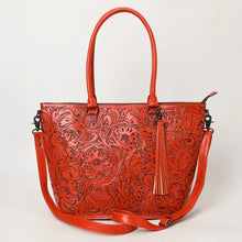 Load image into Gallery viewer, Maple Creek hand tooled leather concealed carry tote in red, front view with antiqued floral tooling, fringe tassel and shoulder strap
